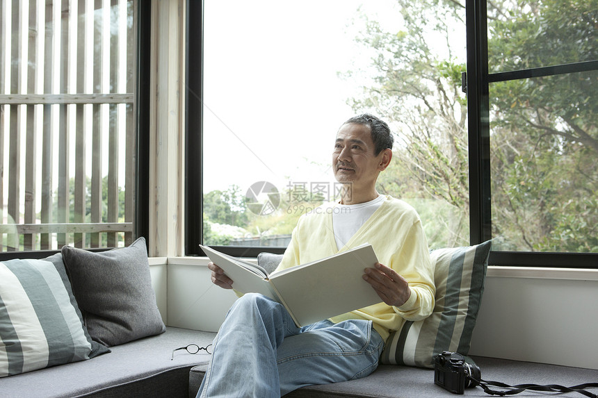 客厅沙发上看书的中老年男性图片