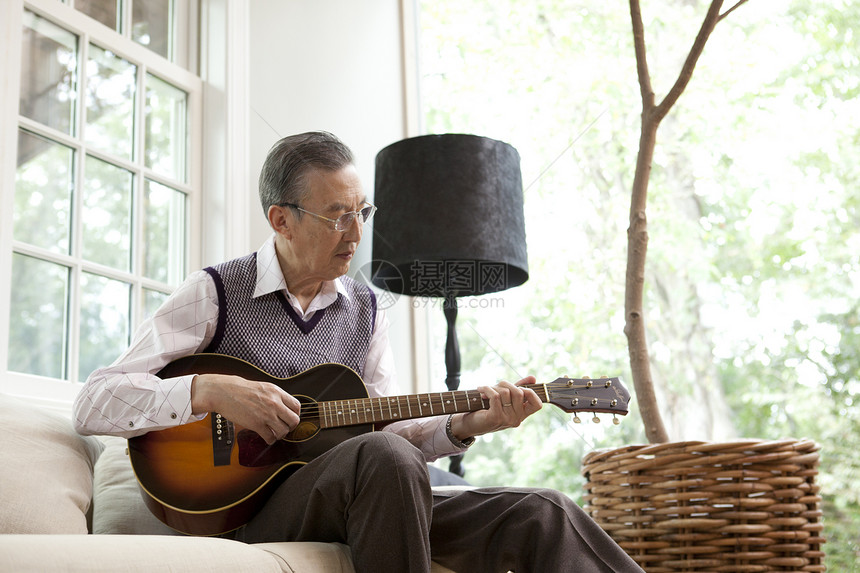 老年男性独自在家弹吉他图片