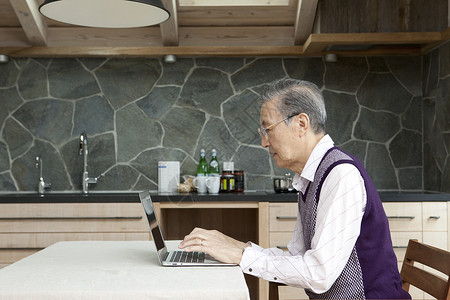 老年男性独自在家使用电脑图片