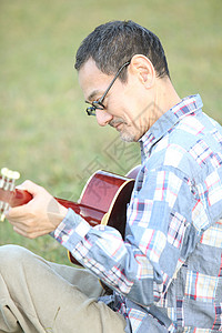 公园户外中老年男性弹吉他图片