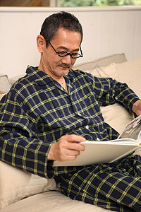 爷爷穿着睡衣坐在沙发上看书图片