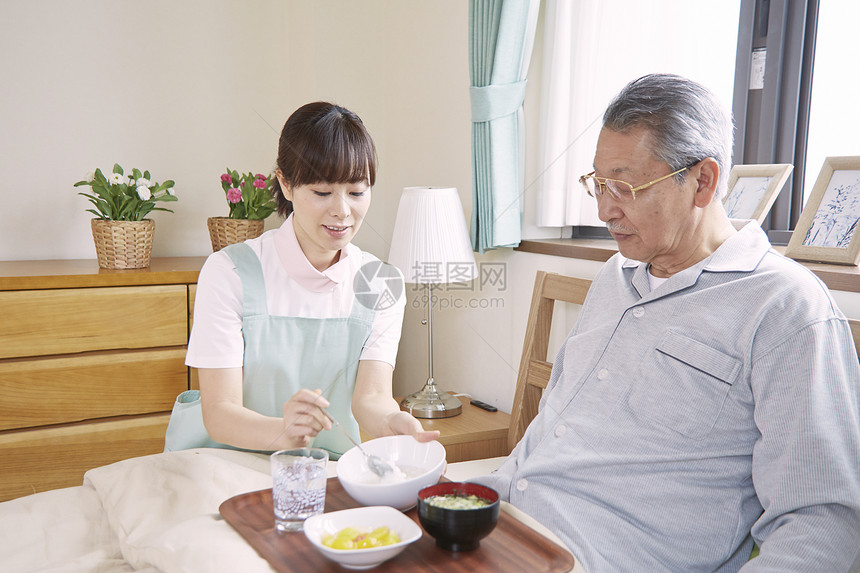 护理员在给老人喂饭图片