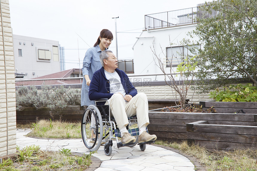 护理员推着坐在轮椅上的老人图片