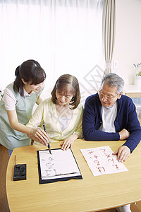 护工在指导老人练习书法图片