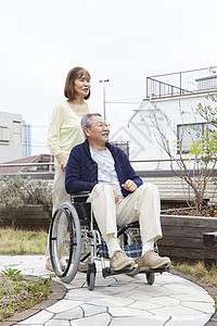 老年夫妇在推行轮椅背景图片