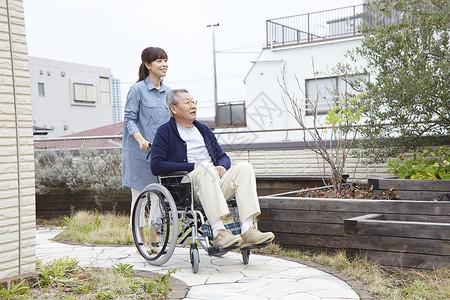 女儿照顾轮椅上的老人花园散步图片