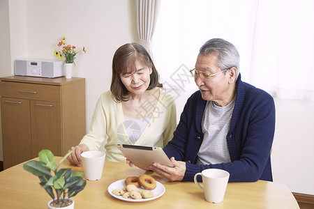 居家老年夫妻吃饭时看平板电脑图片