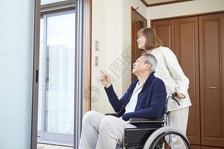 奶奶推着轮椅上的爷爷看窗外图片
