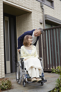 爷爷推着轮椅上的奶奶出门散步图片