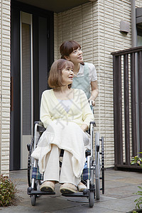 护工推着轮椅上的奶奶出门散步图片