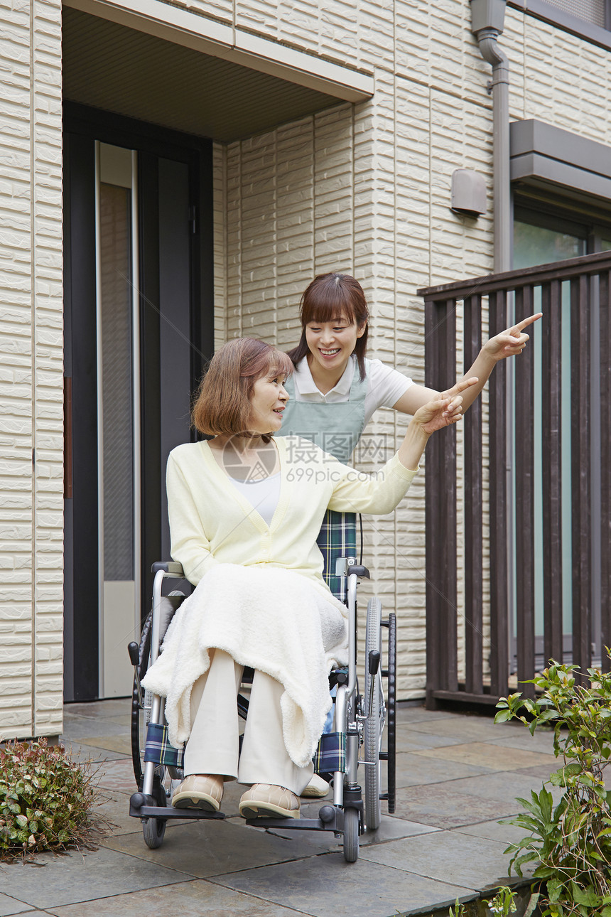 护工推着轮椅上的奶奶出门散步图片