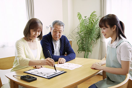 女性护工陪伴居家老人写书法图片
