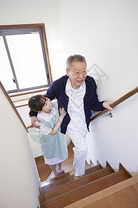 护工搀扶行动不便的老人上楼梯图片