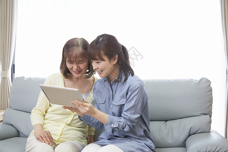 女儿教年迈的母亲使用平板电脑图片