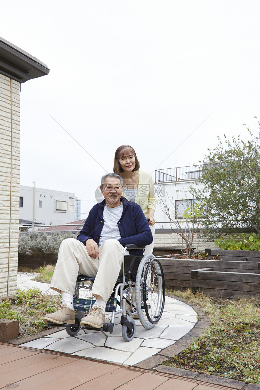 老年女性推着轮椅上的丈夫图片