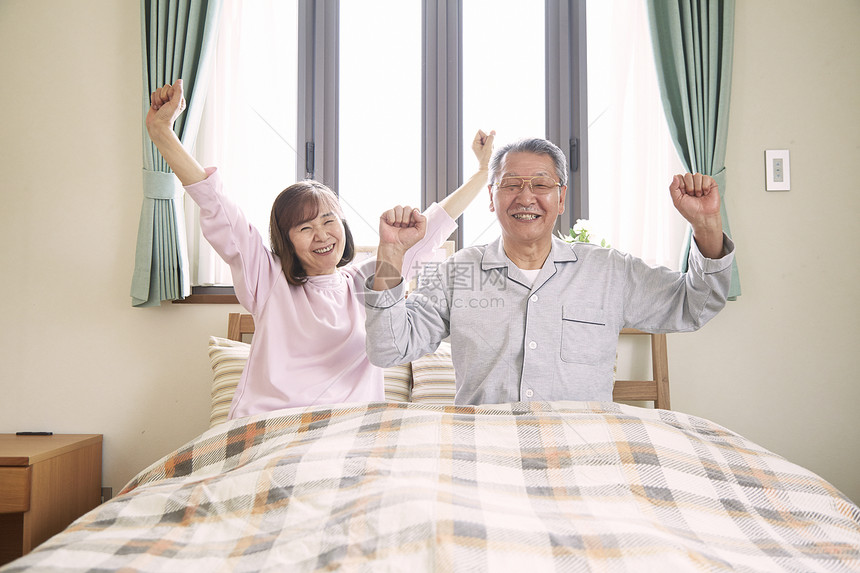 老年夫妇在床上伸懒腰图片