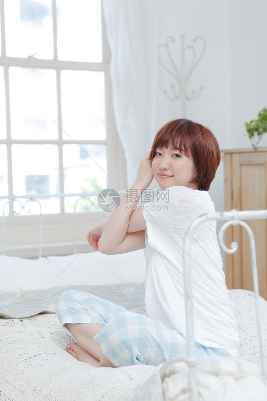 床上伸懒腰的女性图片
