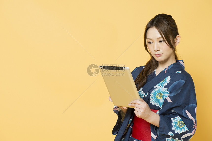 年轻女性穿着和服夏浴衣看平板电脑图片