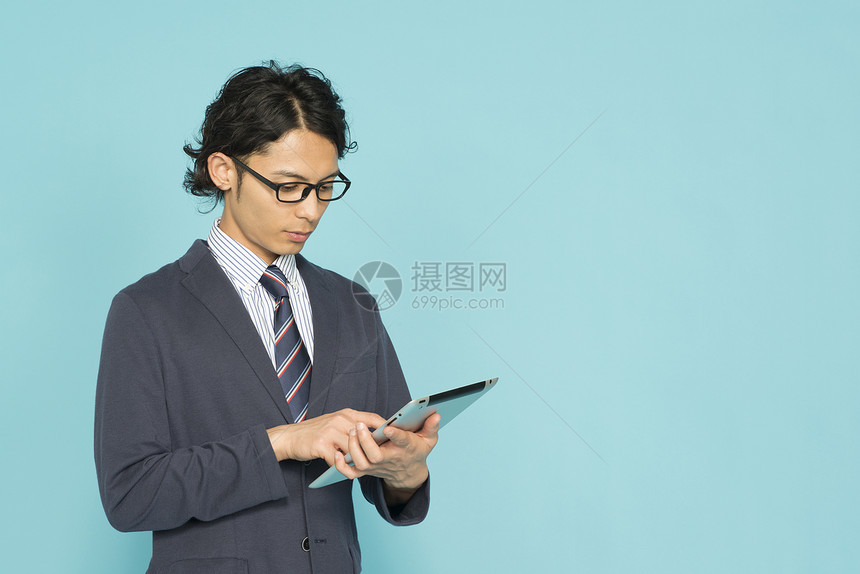 西装男士拿着平板电脑图片