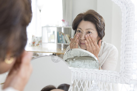 老年女性镜子前保养皮肤高清图片