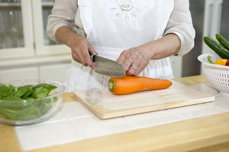 女性厨师在切胡萝卜图片