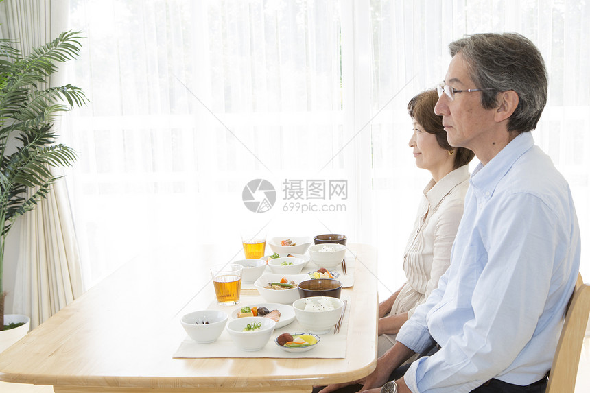 餐桌上准备就餐的中年夫妇图片