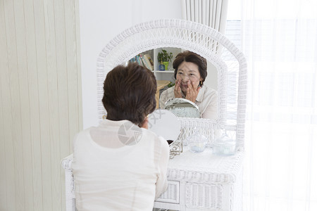 正在镜子前化妆的中年女性图片