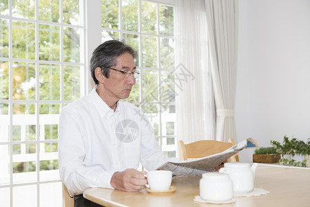 喝咖啡看报纸的老年男性图片