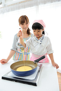 女孩和母亲在学习烹饪图片