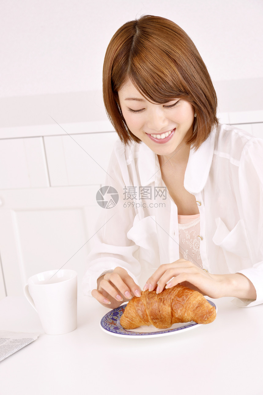 年轻女性吃面包图片