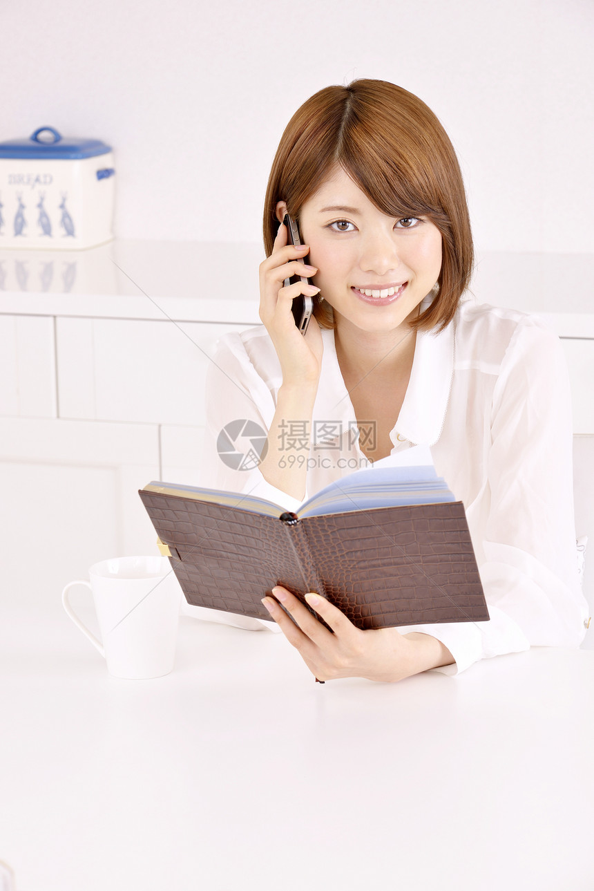 年轻女性看笔记本时打电话图片