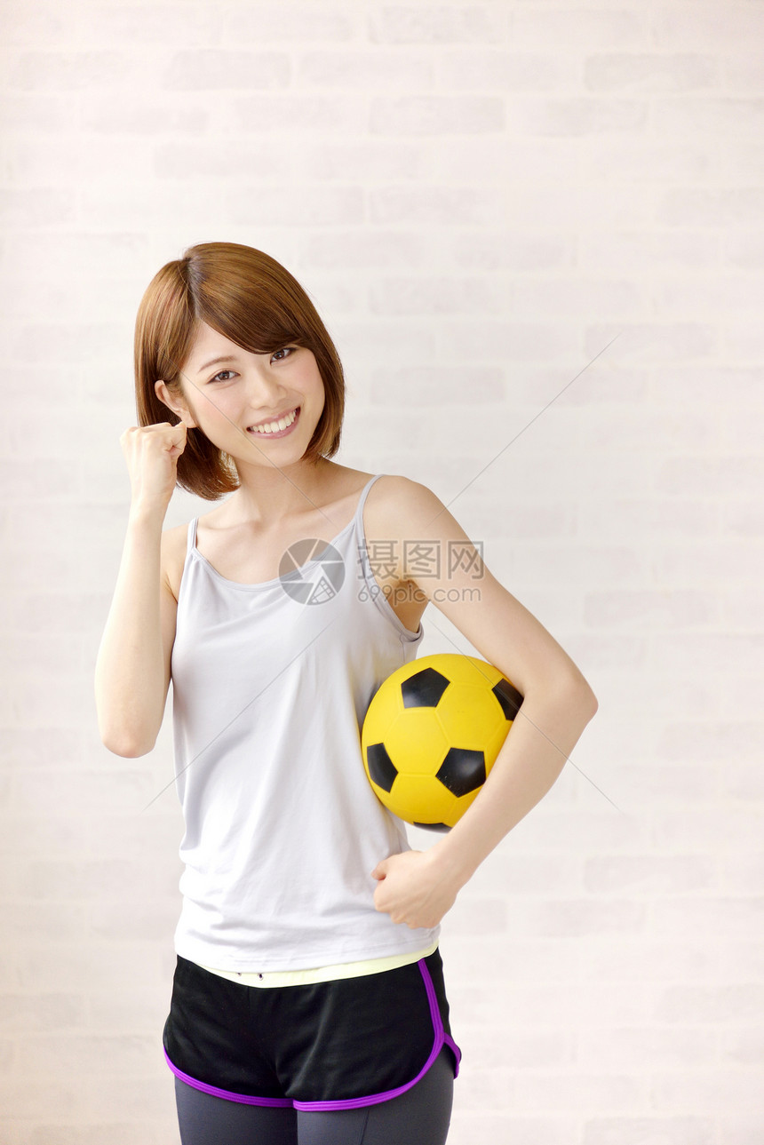 拿着足球运动的健身女性图片
