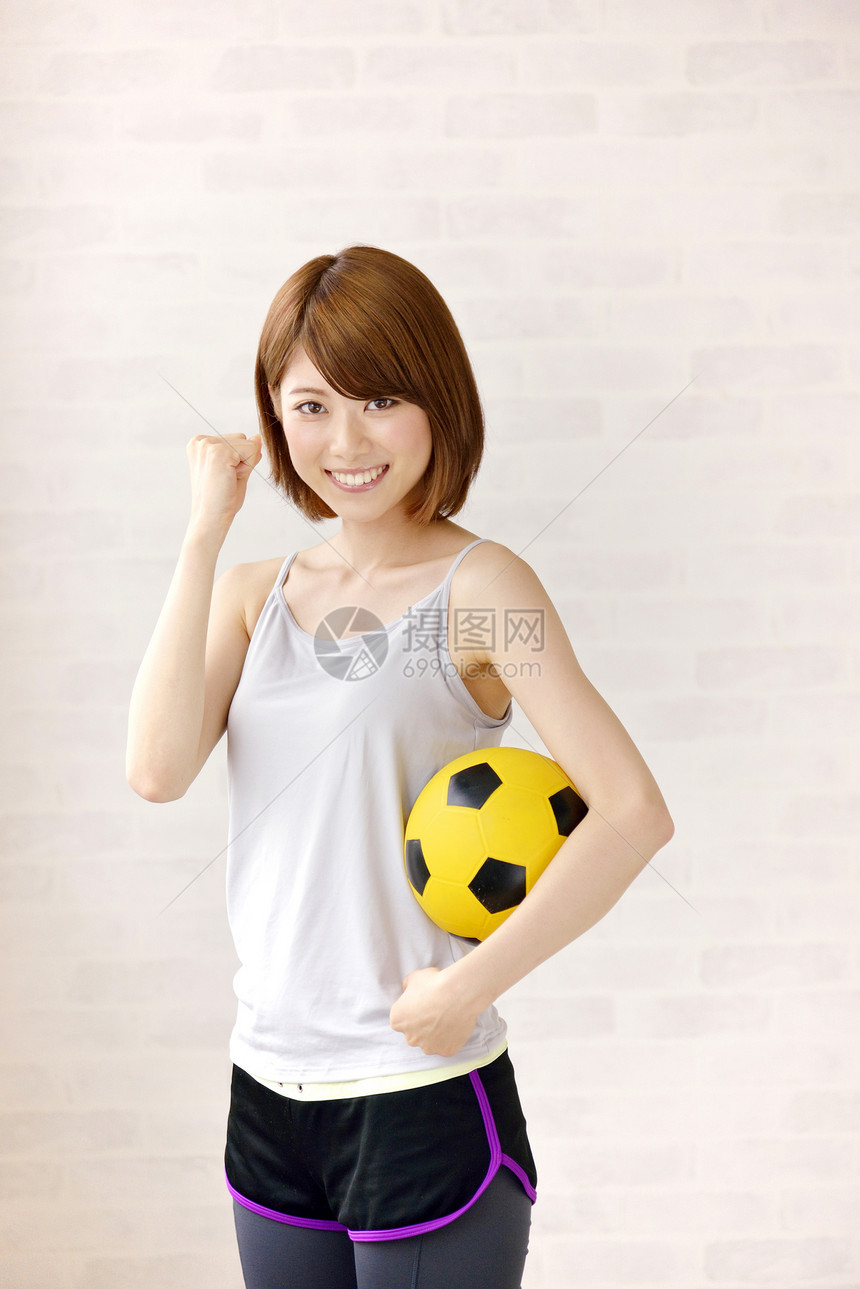 抱着足球的运动少女图片