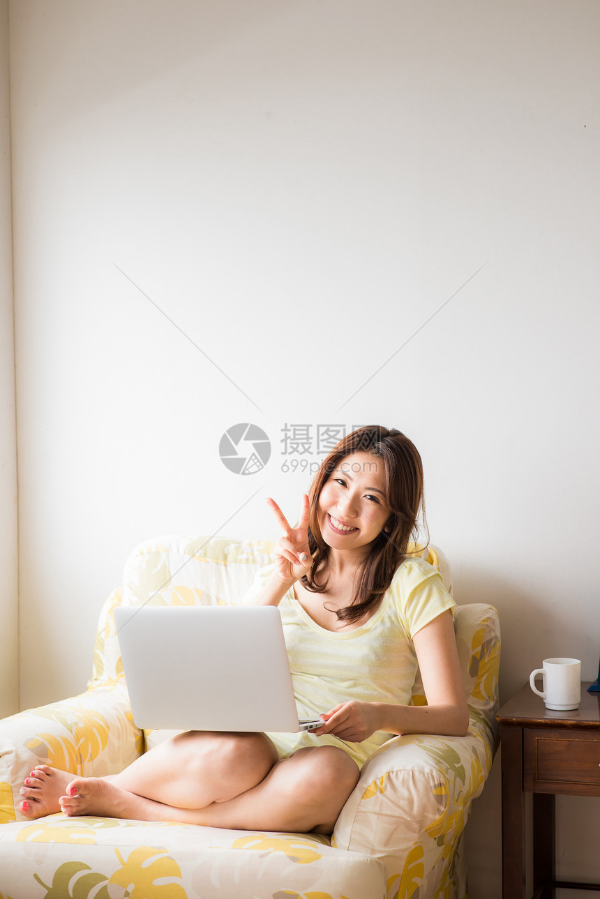 沙发上使用电脑的女人图片