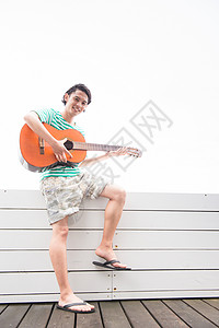 阳台上弹吉他的青年男性图片