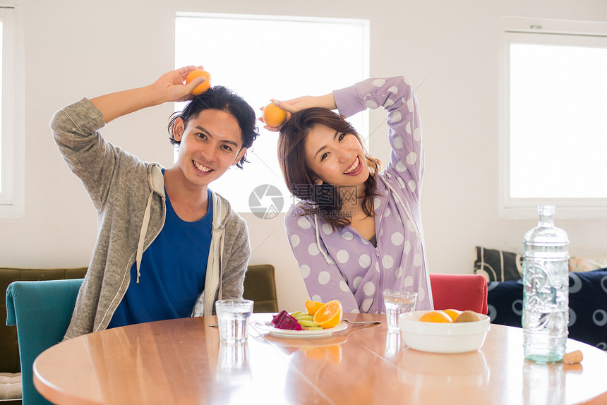 手拿橙子的恩爱夫妇形象图片