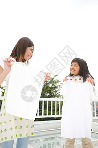 母亲和女儿在户外晾晒衣服图片