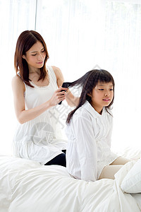 母亲给女儿梳头发背景图片