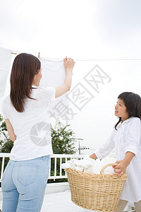 女儿帮助妈妈在天台晾晒衣物图片
