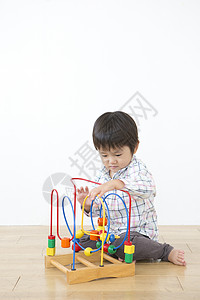 小男孩坐在地上玩玩具图片