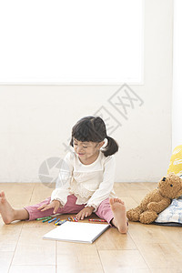 小女孩独自坐在地上画画图片
