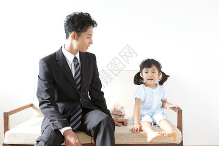商务男士和小女孩坐在沙发上图片