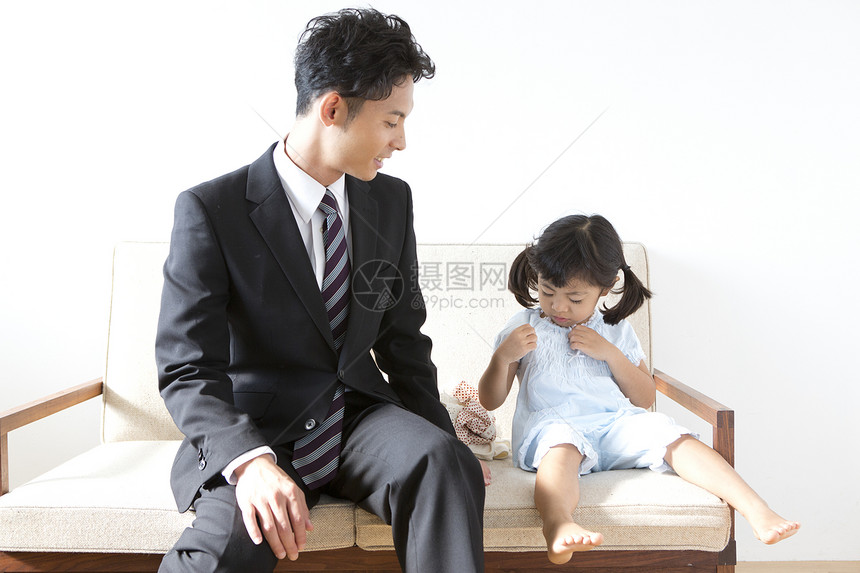 小女孩和父亲在沙发上玩耍图片