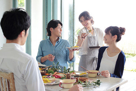 家庭聚会上给朋友准备食物的女性图片