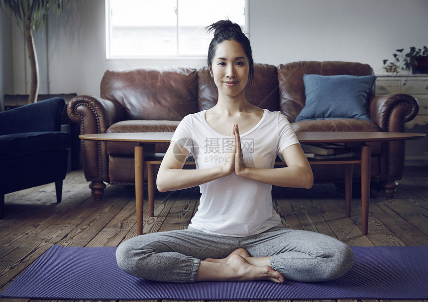 在瑜伽垫上锻炼的女性图片