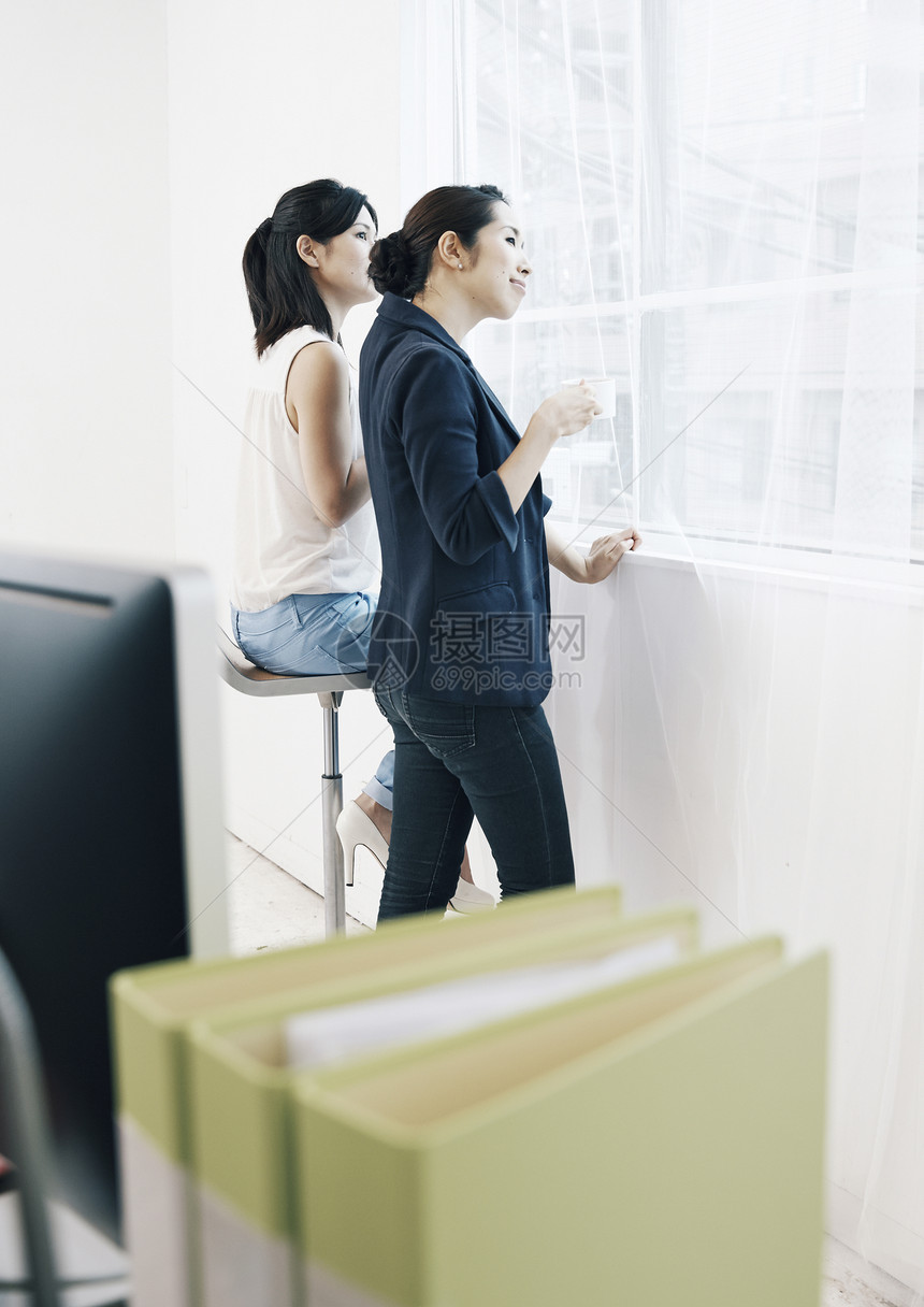 窗边聊天的女性商务人像图片