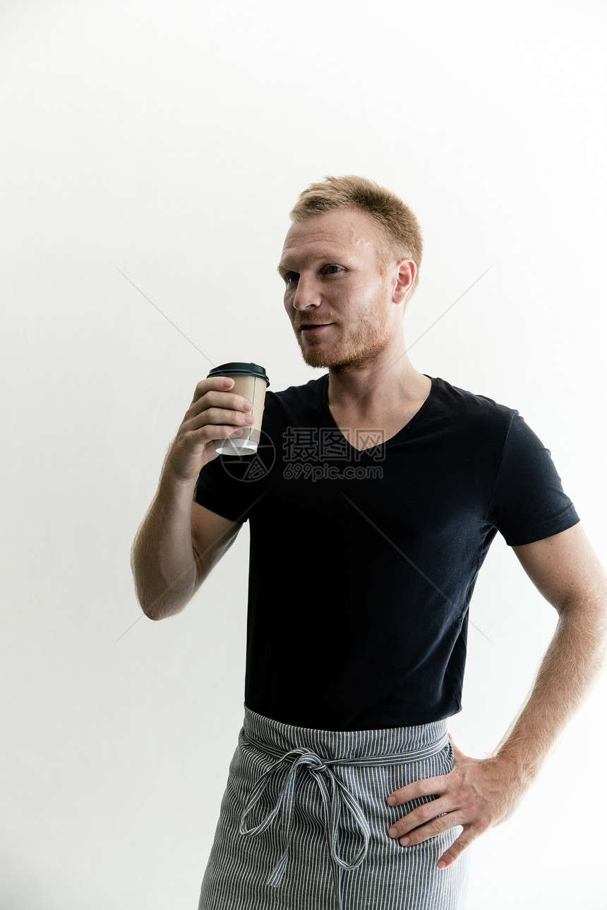 拿着咖啡杯站立的男性图片
