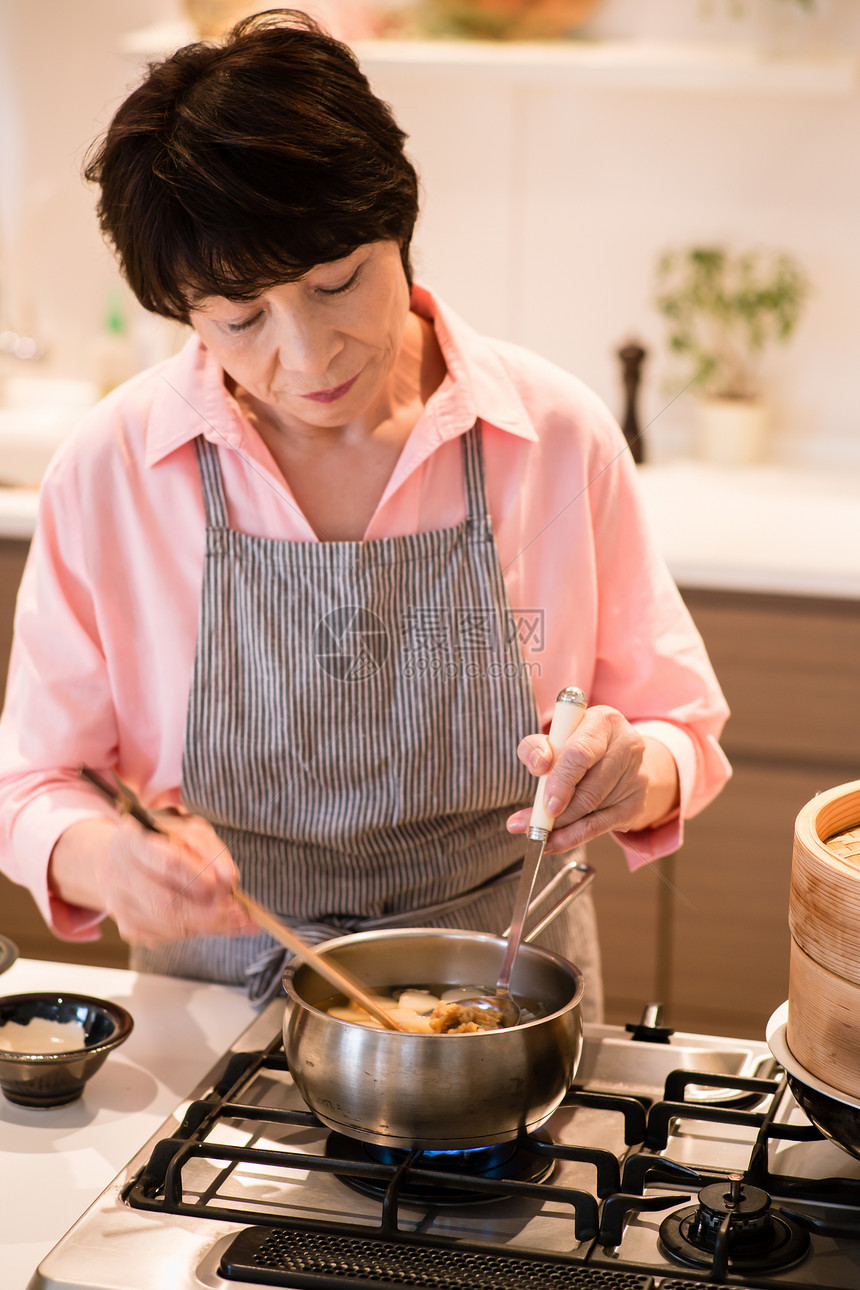 在烹饪食物的中老年女性图片