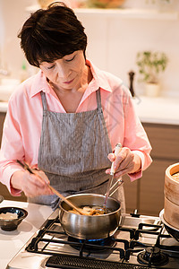 在烹饪食物的中老年女性图片