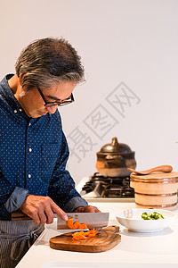 在烹饪食物的老年男性高清图片